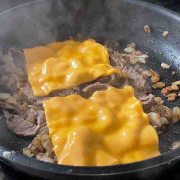 Melt cheese over steak and onions