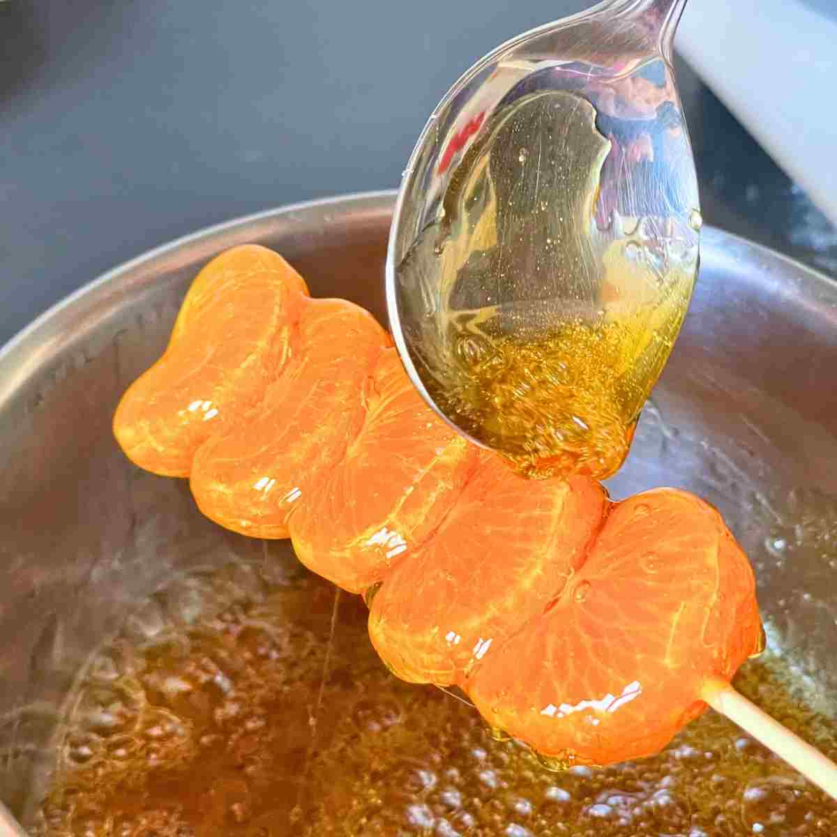 use a spoon to sugar coat tangerine skewer
